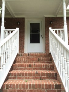 Beautiful, brick steps lead to front porch and front door with new storm door